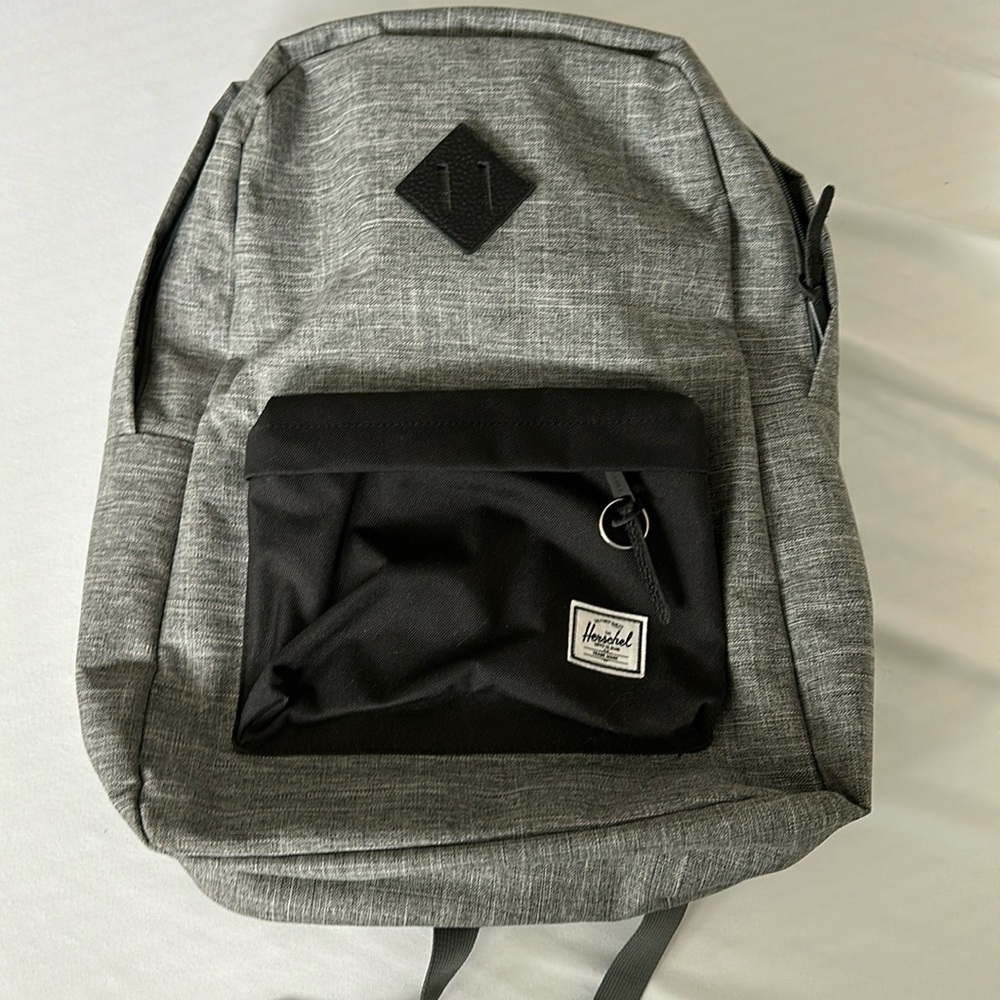 Herschel backpack. Textured grey with black details and red/white stripe inside